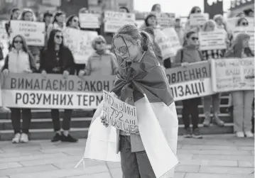  ?? OLEKSII CHUMACHENK­O Sipa USA ?? A girl holds placard that reads, “Dad has been at war for 792 days already. How much more?” as she takes part in a rally Saturday in Kyiv, Ukraine, calling for changes to the terms of length of service in the army, being on the frontline and fair rotation.