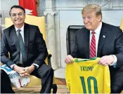  ??  ?? Donald Trump and Jair Bolsonaro exchanged football shirts when they met in the Oval Office at the White House