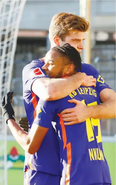  ??  ?? RB Leipzig’s Alexander Sorloth celebrates with team-mate Christophe­r Nkunku after scoring a goal against Freiburg during their German League match on Saturday.