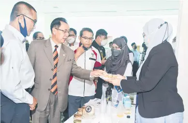  ?? — Gambar PENERANGAN ?? TERTARIK: Dr Rundi (dua kiri) melihat inovasi produk yang dipamerkan pada Agroinvest Sarawak 2022 di Kuching. Turut kelihatan Zabawi (kiri) dan Edwin (tiga kiri).