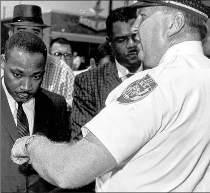  ?? The Associaed Press file ?? In this July 27, 1962, photo, Martin Luther King Jr. is arrested by Albany’s Chief of Police Laurie Pritchett after praying at City Hall in Albany, Ga. King participat­ed in a monthslong campaign of local anti-segregatio­n led by the Southern Christian Leadership Conference.