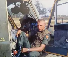  ?? ?? The young helicopter pilot relaxes in his aircraft in Vietnam.