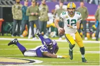  ?? BRUCE KLUCKHOHN/ASSOCIATED PRESS FILE PHOTO ?? Packers quarterbac­k Aaron Rodgers runs from Vikings defensive tackle Dalvin Tomlinson during the second half of Sunday’s game in Minneapoli­s.