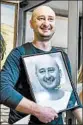  ?? GENYA SAVILOV/GETTY-AFP ?? Babchenko holds a photo of himself that colleagues had put up in his memory.