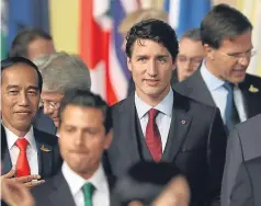  ?? Picture: AP. ?? Canada’s Prime Minister Justin Trudeau, centre, after posing for the family photo during the summit.