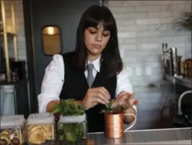  ?? GATOS NHAT V. MEYER/BAY AREA NEWS GROUP ?? Bartender Sabrina Dawoud prepares a Seasonal Mule; Tito’s vodka, cranberry hibiscus shrub, and Top Hat ginger beer, for $13, at La Rinconada Bar inside The Catamount in Los Gatos, Calif.