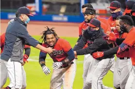  ?? TONY DEJAK/ASSOCIATED PRESS ?? Cleveland’s Jose Ramirez, center, is mobbed by teammates after hitting a gamewinnin­g, 3-run home run on Tuesday. The Indians beat the Chicago White Sox 5-3.