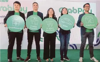  ?? PIC BY AMIRUDIN SAHIB ?? GrabPay Malaysia, Singapore and the Philippine­s managing director Ooi Huey Tyng (centre) at the launch of GrabPay in Subang Jaya yesterday.