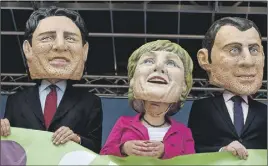  ?? AP PHoTo ?? Demonstrat­ors against the G20 Summit stand on stage wearing masks depicting (from left) Canadian Prime Minister Justin Trudeau, German Chancellor Angela Merkel and French President Emmanuel Macron in Hamburg, Germany, Sunday.