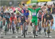  ?? AP PHOTO/DANIEL COLE ?? Britain’s Mark Cavendish, wearing the best sprinter’s green jersey, celebrates with teammate in background Denmark’s Michael Morkov, as he crosses the finish line Tuesday to win the tenth stage of the Tour de France.