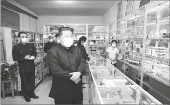  ?? PHOTO VIA AP ?? In this photo provided by the North Korean government, North Korean leader Kim Jong Un, center, visits a pharmacy in Pyongyang, North Korea on May 15.