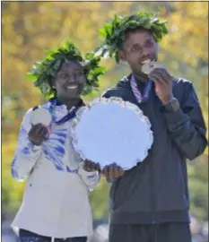  ?? SETH WENIG - THE ASSOCIATED PRESS ?? First place finishers Mary Keitany of Kenya, left, and Lelisa Desisa of Ethiopia pose for a picture at the finish line of the New York City Marathon Sunday.