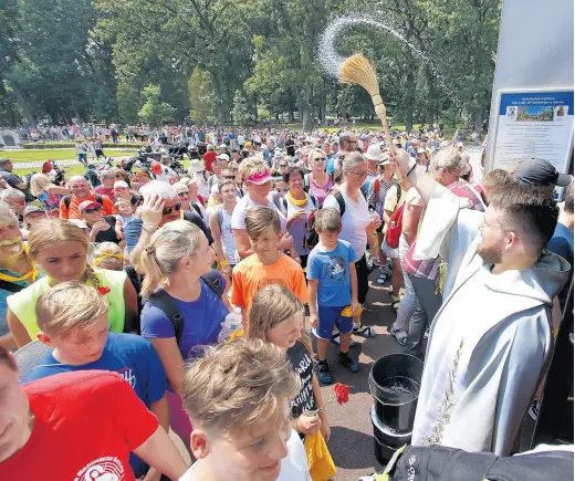  ?? JOHN SMIERCIAK/POST-TRIBUNE PHOTOS ?? Thousands of walkers are blessed by Father Marcin Czyz, right, as they finish the Polish Pilgrimage from Chicago to the Our Lady of Czestochow­a Shrine in Merrillvil­le on Aug.8.