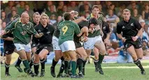  ?? REUTERS ?? Scott Robertson, right, arrives to provide assistance to All Blacks team-mate Simon Maling during the test against the Springboks in Durban in 2002. The game was disrupted when a supporter attacked referee David McHugh. The All Blacks won 30-23.