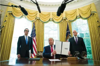  ?? Associated Press file photo ?? ■ President Donald Trump holds up a signed executive order to increase sanctions on Iran June 24 in the Oval Office with Treasury Secretary Steven Mnuchin, left, and Vice President Mike Pence. Trump is now three for three. Each year of his presidency, he has issued more executive orders than did former President Barack Obama during the same time-span.