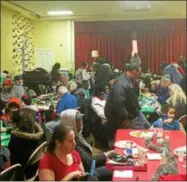  ?? FILE PHOTO ?? A large crowd enjoys a previous free holiday community meal hosted by Kingdom Ministries in Troy.