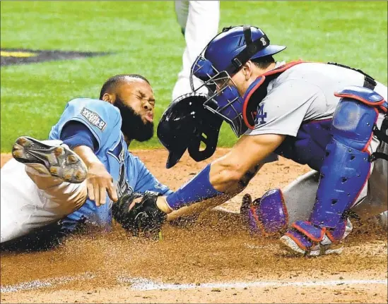  ?? Photog r aphs by Wally Skalij Los Angeles Times ?? DODGERS CATCHER
Austin Barnes tags out Tampa Bay’s Manuel Margot at home on a straight steal attempt. The aggressive move stunted the Rays’ momentum.