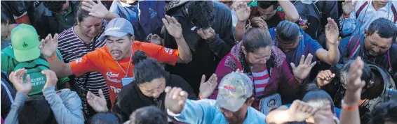  ?? RODRIGO ABD, THE ASSOCIATED PRESS ?? Central American migrants, part of the caravan heading for the U.S. border, pray at a temporary shelter in Tijuana, Mexico, on Friday.