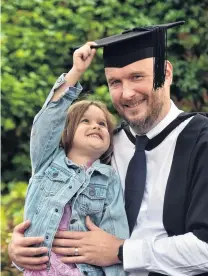  ?? ?? Well earned . . . Graduate Gareth Price, of Invercargi­ll, celebrates the completion of years of hard work with his daughter Taylor (4) during the Otago University Graduation on Saturday.