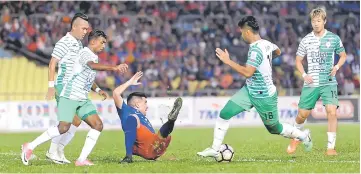  ?? — Bernama photo ?? JDT player Gabriel Guerra (on ground) being closely guarded by Melaka United players.