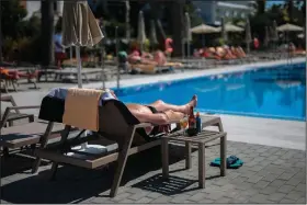  ??  ?? A German tourist sunbathes at the Riu Concordia hotel swimming pool in Palma de Mallorca, Spain, in mid-June.
(AP/Joan Mateu)