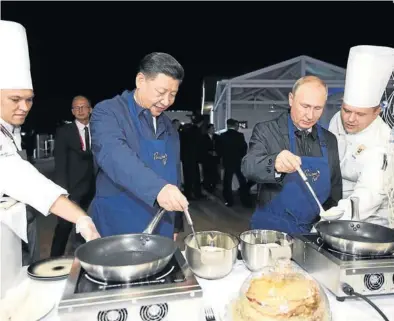  ?? AFP / SERGEI BOBYLYOV ?? Xi Jinping y Vladímir Putin cocinan unas crepes para almorzar, ayer en Vladivosto­k (Rusia). ▶▶