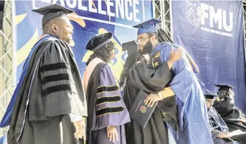  ?? PEDRO PORTAL pportal@miamiheral­d.com ?? FMU faculty members greet student Perontay Cecil Antonio Fawkes, a business graduate, during the spring commenceme­nt ceremony at Florida Memorial University in Miami Gardens on Saturday.