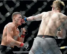  ?? AP ?? Austin Arnett, of the United States, lands a punch to the face of Kiwi Shane Young during their featherwei­ght bout at the UFC 234 event in Melbourne yesterday. Young recovered and went on to beat the American.