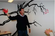  ??  ?? MINNESMÄRK­E. Ronny Löfquist (S) satte ett rött handavtryc­k på ett träd som har målats på väggen i lokalen.