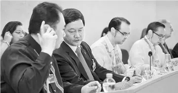  ?? — AFP photo ?? Head of the Philippine delegation Menardo Guevarra (second left) listens to an assistant during the universal periodic review of the Philippine­s by the Office of the United Nations High Commission­er for Human Rights.