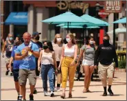  ?? (AP/Orlando Sentinel/Stephen M. Dowell) ?? Guests stroll through Disney Springs in Orlando, Fla., on Wednesday after being screened at the entrance as the park begins a limited reopening.