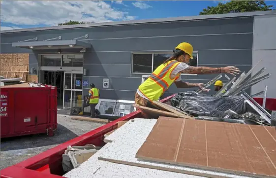  ?? Steve Mellon/Post-Gazette ?? Workers remove debris from a heavily damaged plasma donation center on the North Side on Tuesday. The Biomat building on Western Avenue has been closed since Saturday, when a vehicle traveling at high speed crashed into the structure, killing two employees and another person.