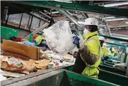  ?? Lea Suzuki/The Chronicle 2019 ?? Material handler Tyrell Jones removes plastic bags from a conveyor belt at Recology’s Recycle Central.