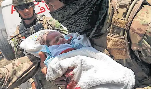  ?? PHOTO: STR/AFP ?? Rescue mission:
An Afghan security guard carries a newborn baby from a Kabul hospital, the site of an attack by gunmen.