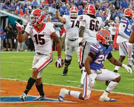  ?? CURTIS COMPTON / CCOMPTON@AJC.COM ?? Georgia wide receiver Lawrence Cager gets past Florida defensive back Jeawon Taylor to follow his 52-yard touchdown reception with a catch on a two-point conversion attempt to give the Bulldogs a 24-10 lead during the fourth quarter Saturday.