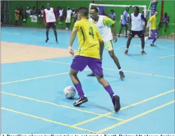  ??  ?? A Brazilian player (yellow) tries to get past a North Ruimveldt player during their clash in the Street Vybz Entertainm­ent Futsal Championsh­ip at the National Gymnasium Saturday night. Pix saved as Brazilian2