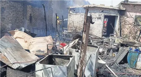  ?? FOTO: CORTESÍA ?? Uno de los Bomberos de Los Mochis extingue las llamas que acabaron con las pertenenci­as de la familia.