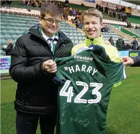  ??  ?? Rickshaw rider Harry Parker gets a special Plymouth Argyle shirt from director James Brent