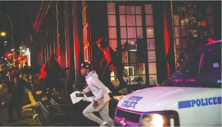  ?? EDUARDO MUNOZ/REUTERS ?? Protesters flee as they loot a store Monday in New York City after marching against the Minneapoli­s police killing of George Floyd. Adding fuel to this outrage is the damage wreaked on America’s unprotecte­d underclass by the COVID-19 pandemic, says Diane Francis.