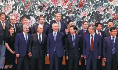  ?? ANDY WONG / REUTERS ?? Vice-Premier Liu He (center) chats with US Commerce Secretary Wilbur Ross (center left) during a group photo session after their meeting at the Diaoyutai State Guesthouse in Beijing on Sunday.