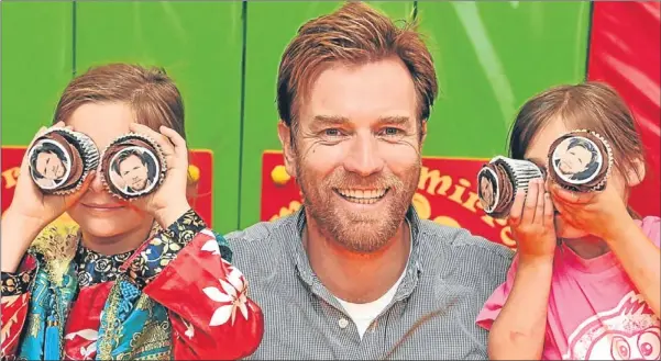  ?? Picture: Rob Mcdougall. ?? Scottish actor Ewan McGregor took time out from a family trip to visit Rachel House, the children’s hospice, in Kinross. Emily, left, and Lilly Horrocks have fun with cakes featuring Ewan’s face. See full report on page 14.