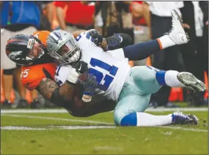  ?? The Associated Press ?? ROUGH GAME: Dallas Cowboys running back Ezekiel Elliott (21) is tackled by Denver Broncos cornerback Chris Harris Sunday in Denver. Elliott was held to 8 yards on nine carries, the worst performanc­e of his career.