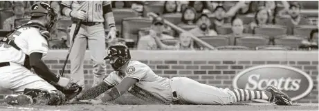  ?? Scott Cunningham / Getty Images ?? Carlos Correa, right, was tagged out at home by Braves catcher Tyler Flowers in the fourth inning and exited with left thumb discomfort.