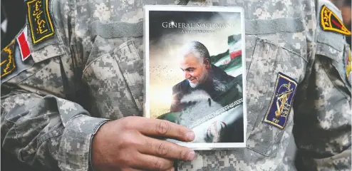  ?? Nazanin Tabatabaee via REUTERS files ?? A demonstrat­or holds a picture of Qassem Soleimani at a protest in Tehran after the general’s death.