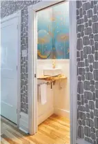  ??  ?? Above: The powder room features gold accents and deep teal blue wallpaper, creating a whimiscal gem of a room