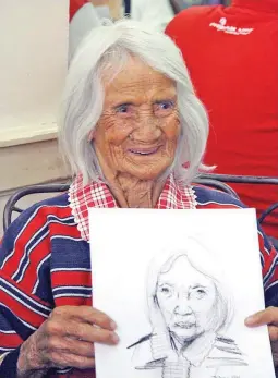  ??  ?? A SMILE FOR THE AGES — Whether she’s 109 or 99, Lakmi Sapigao Guimbongan is still known as the oldest living grandmothe­r in Kapangan, Benguet. Here she smiles after being handed a sketch of herself by one of the artists at the UN Creative Hub in Baguio...