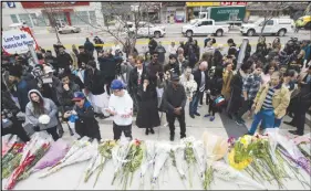  ?? CP PHOTO ?? People read and pay tribute at a memorial for the victims along Yonge Street.