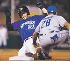  ??  ?? The Isotopes’ Tom Murphy, left, is tagged out at third base by Las Vegas’ Phillip Evans during Tuesday’s home opener.