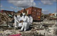  ?? FERNANDO LLANO — THE ASSOCIATED PRESS ?? A Bahamas coroners team carries a body out of The Mudd neighborho­od in the Marsh Harbor area of Abaco Island in the Bahamas in the aftermath of Hurricane Dorian, Monday.