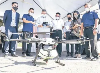  ?? — Bernama photo ?? Saifuddin (third le ) tries his hands on operating a drone at Futurise Center.